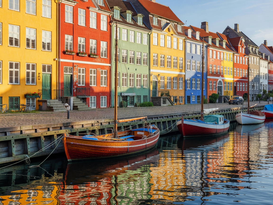 Colorful canal townhouses in Copenhagen with docked wooden boats